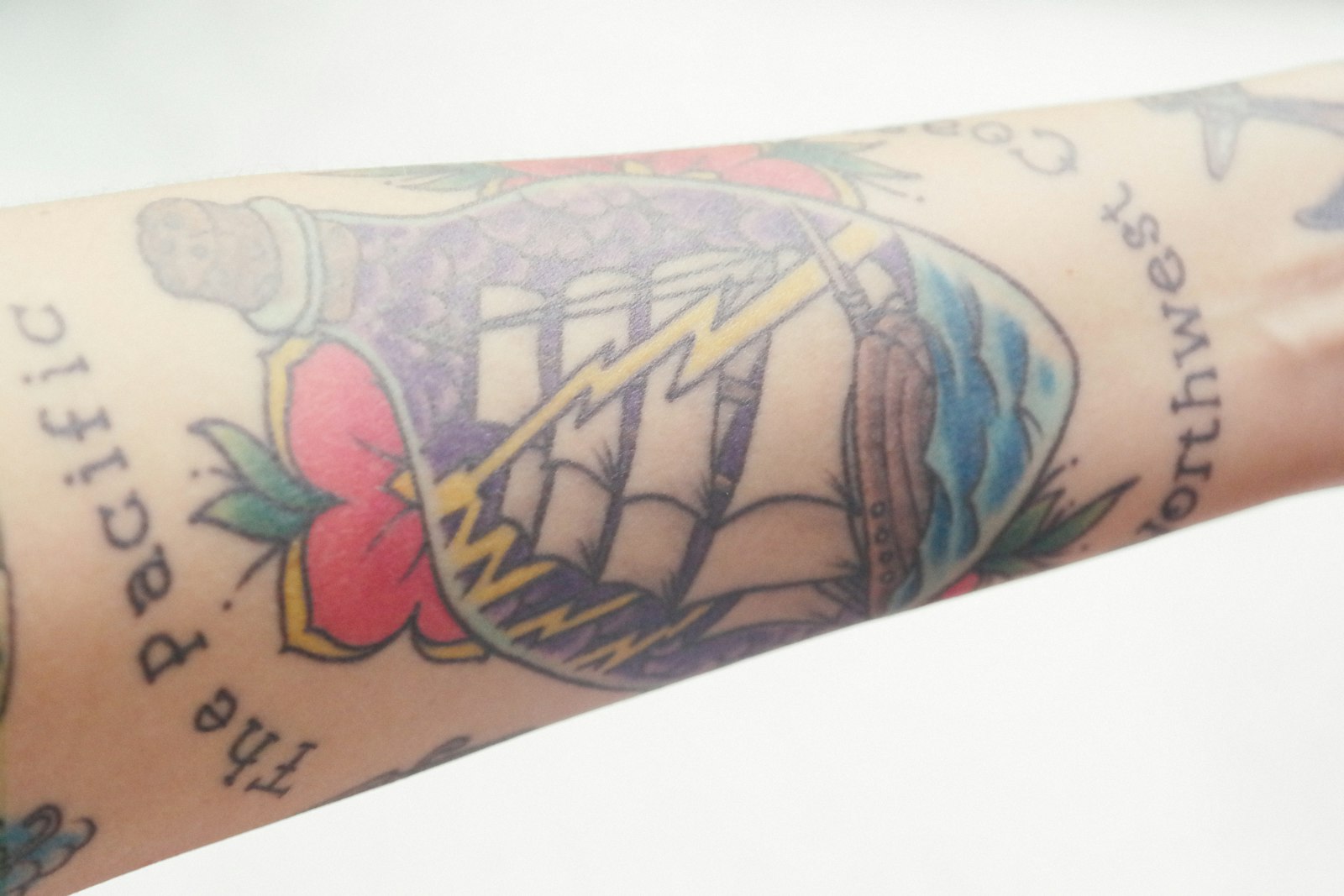 a close up of a person's arm with tattoos on it