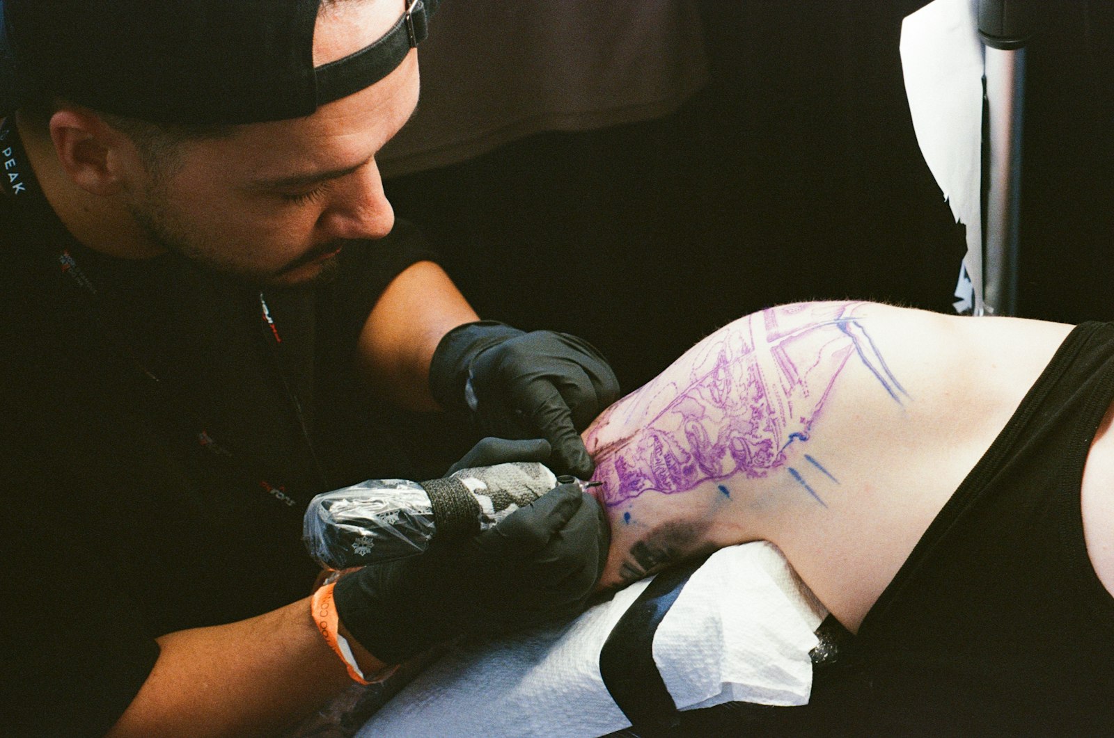 Tattoo artist working on a client's arm