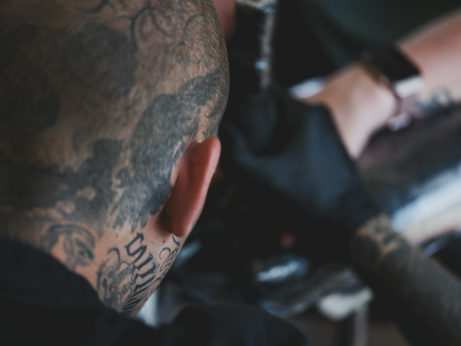 Tattoo artist working on a client's arm