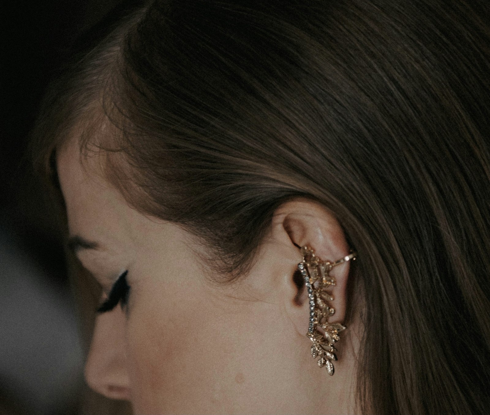 a close up of a person wearing a pair of earrings