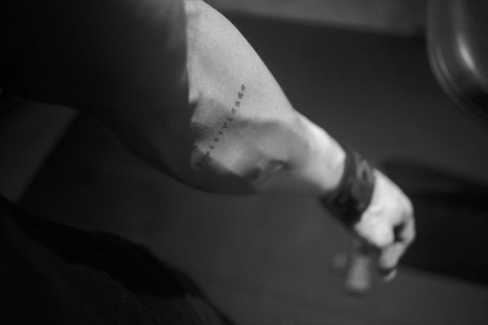 a black and white photo of a person with a tattoo on their arm