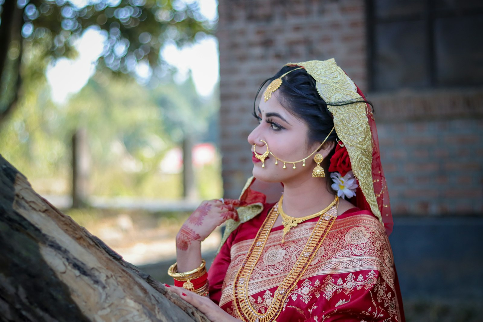 A bride in traditional indian attire with ornate jewelry.