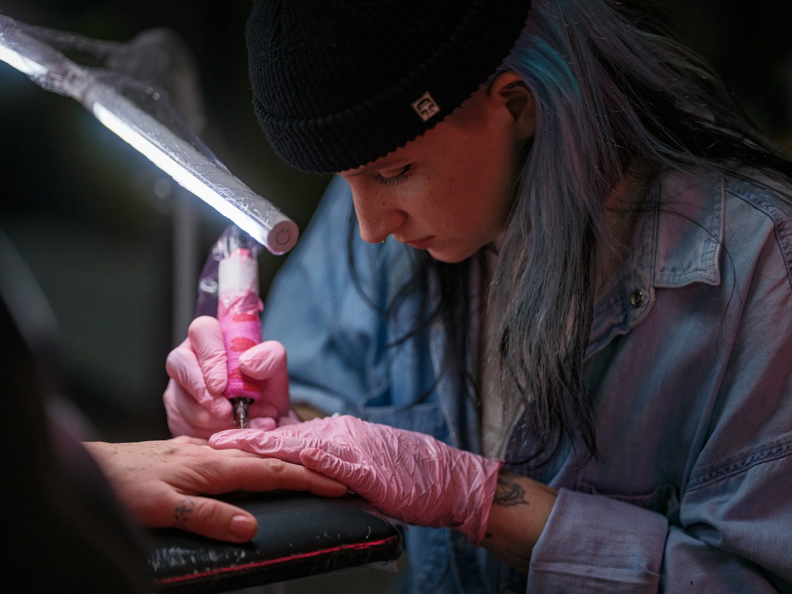 A woman in a black hat and pink gloves