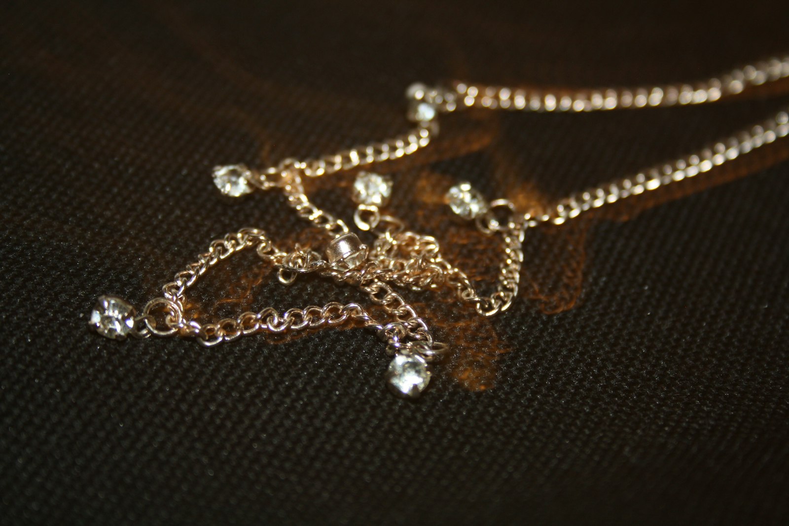 silver beaded necklace on black textile