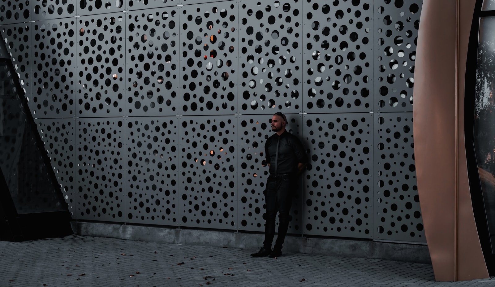 man in black jacket standing on gray concrete floor