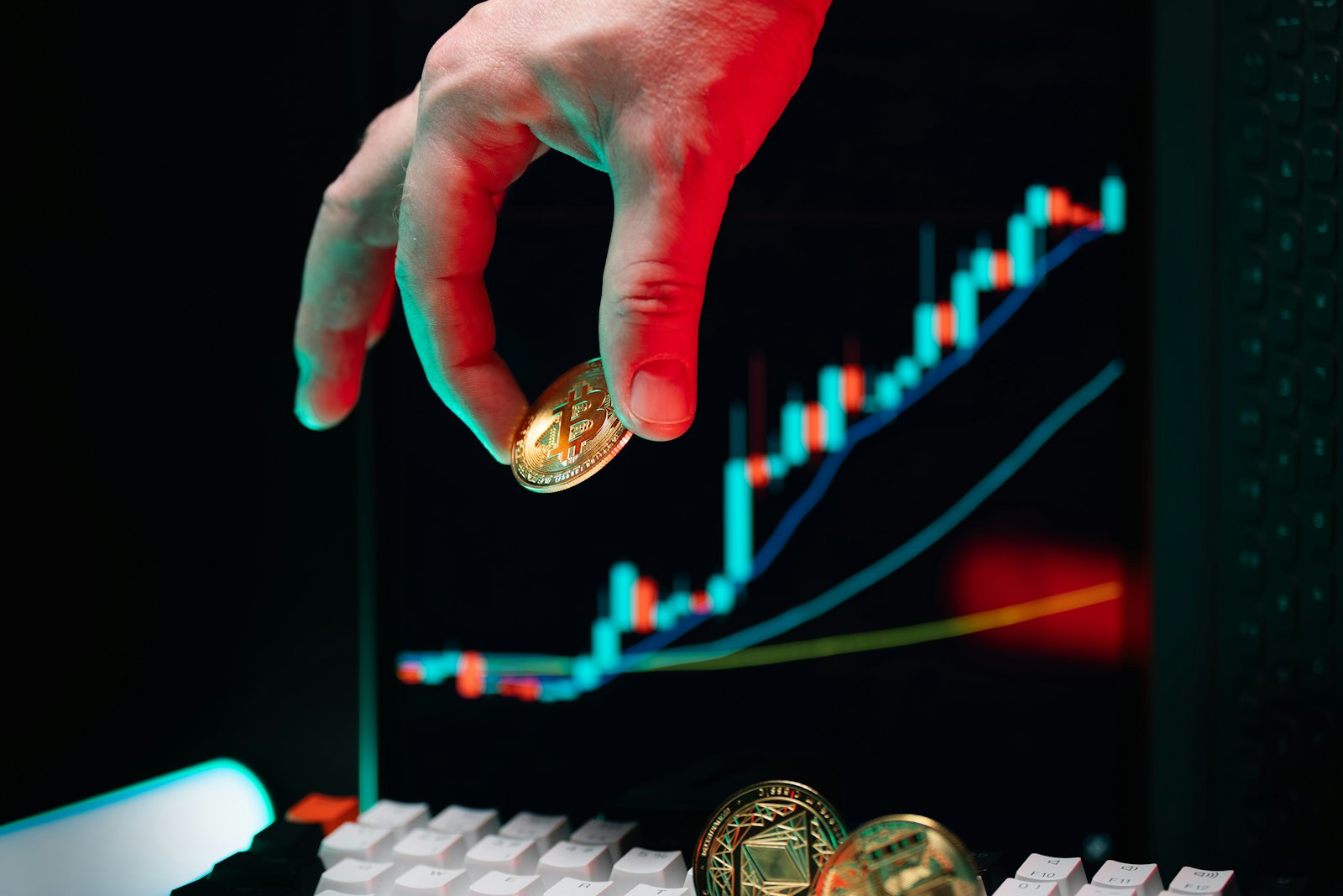 A hand reaching for a coin on a computer keyboard