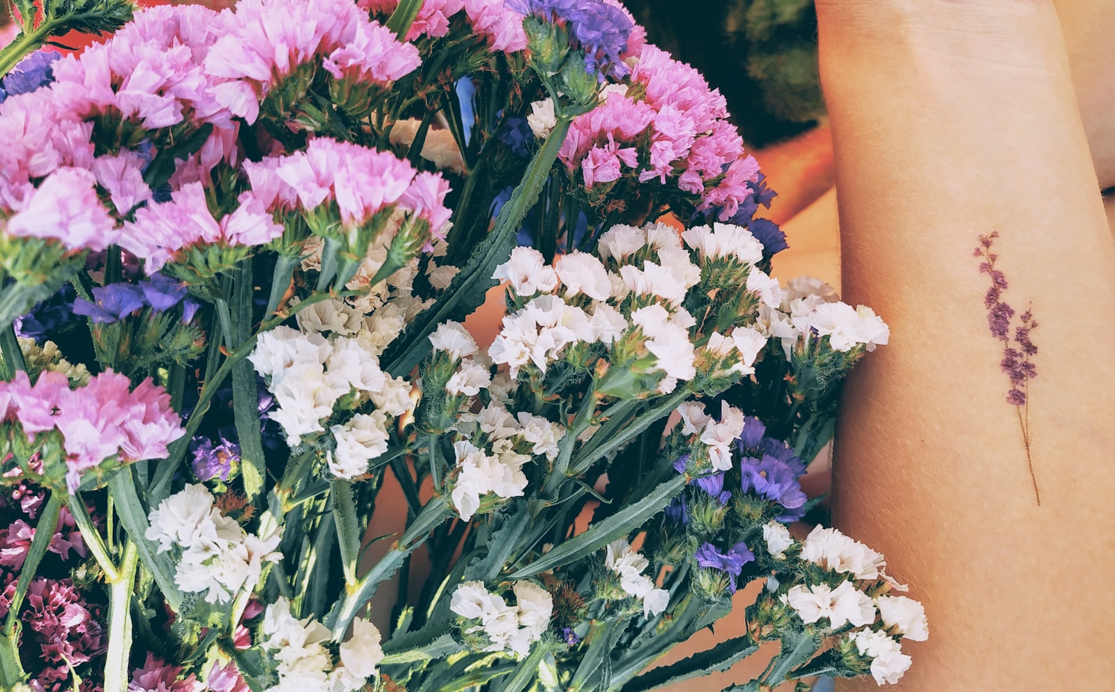 a close up of a person holding a bunch of flowers
