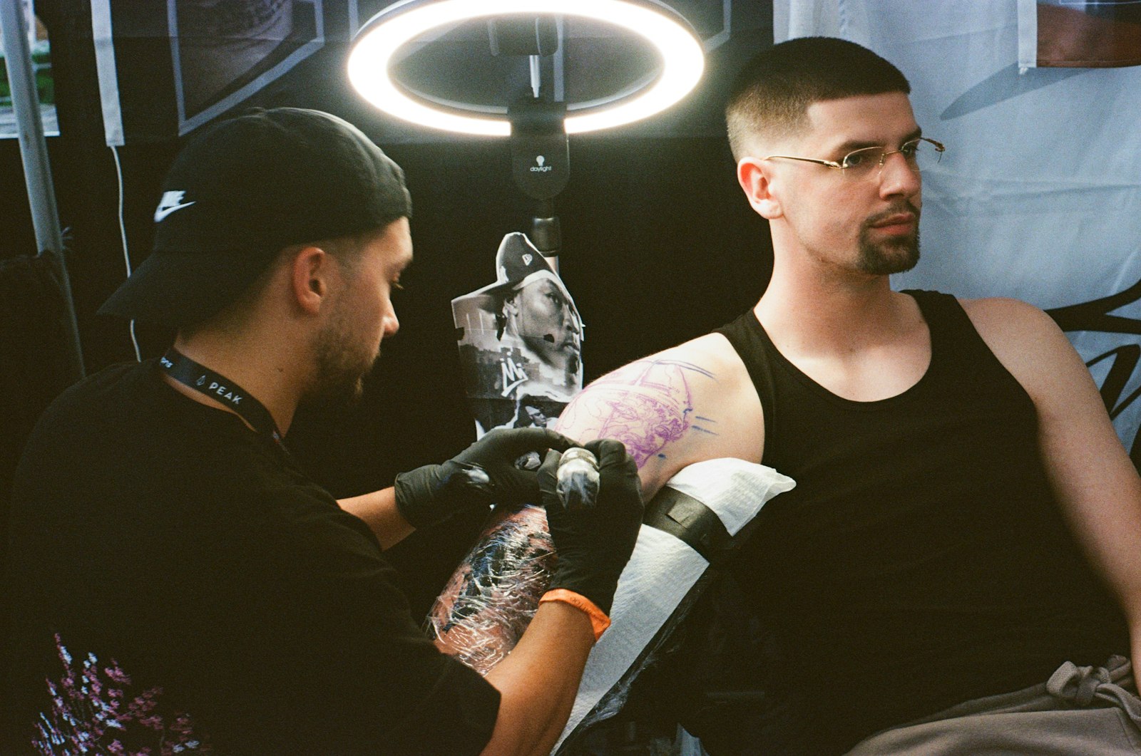 Tattoo artist working on a client's arm