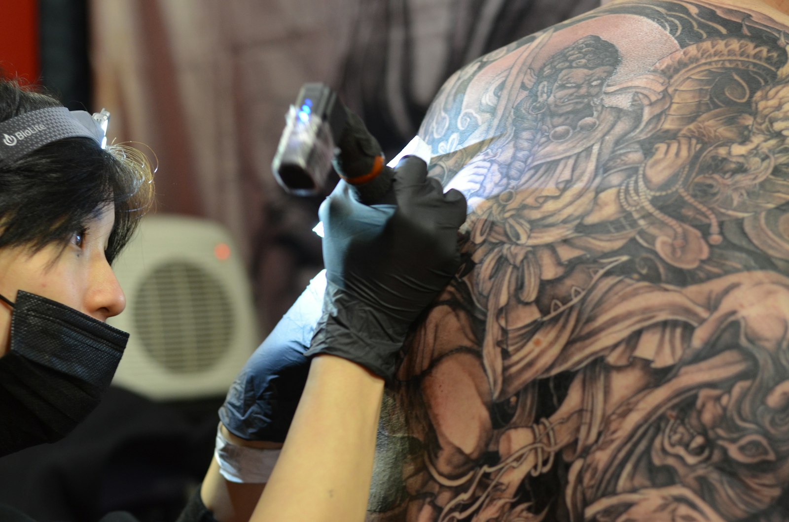 a woman getting a tattoo done on her back
