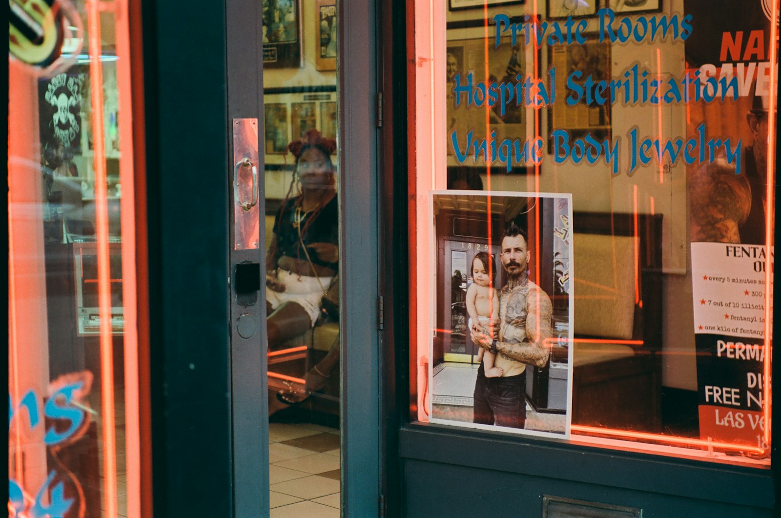 Tattoo parlor entrance with neon lights and displayed art.