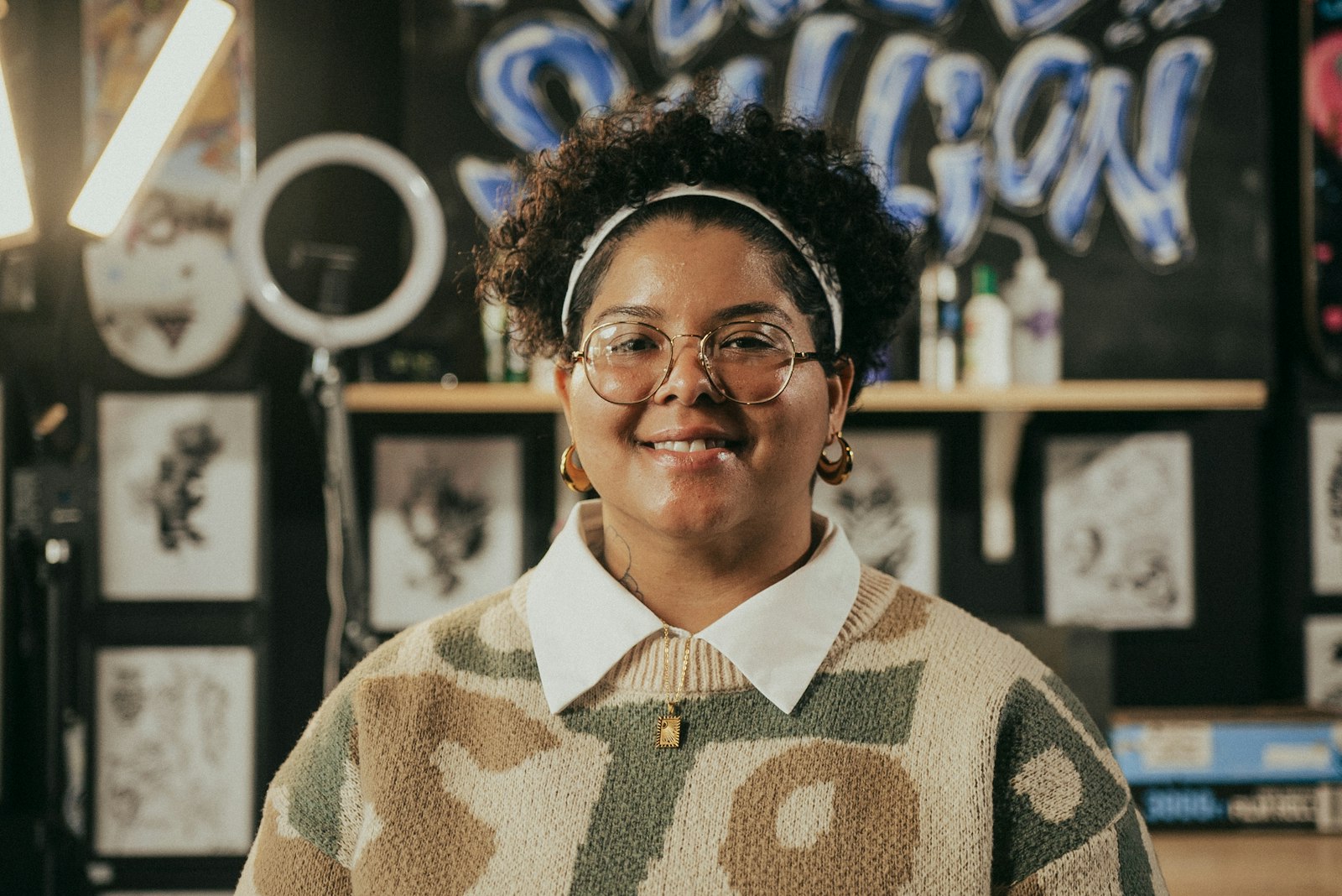 A smiling woman with glasses and curly hair.