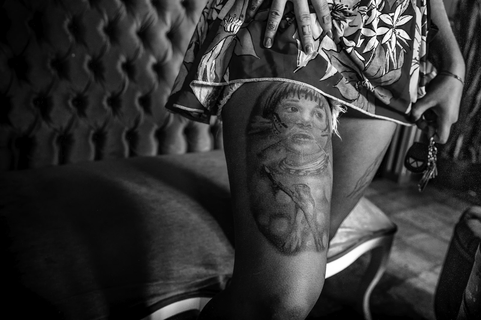 grayscale photo of person showing leg tattoo
